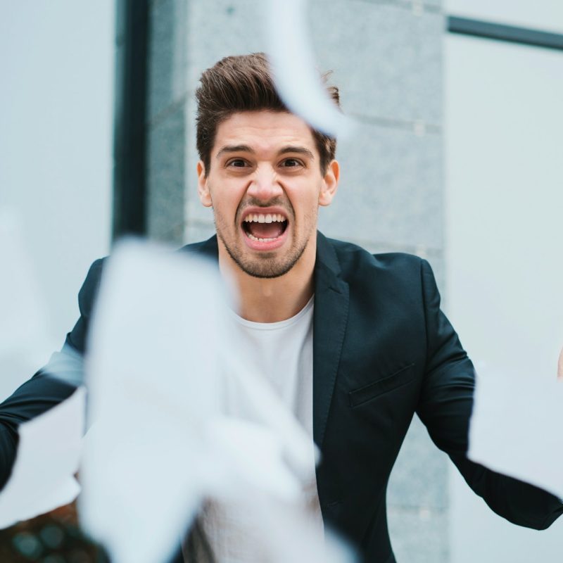 furious male office worker throwing crumpled paper,having nervous breakdown at work, screaming anger